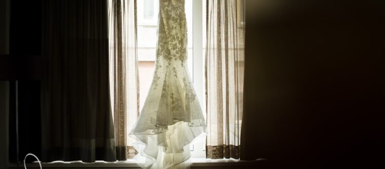 Hochzeitskleid am Fenster im Gegenlicht